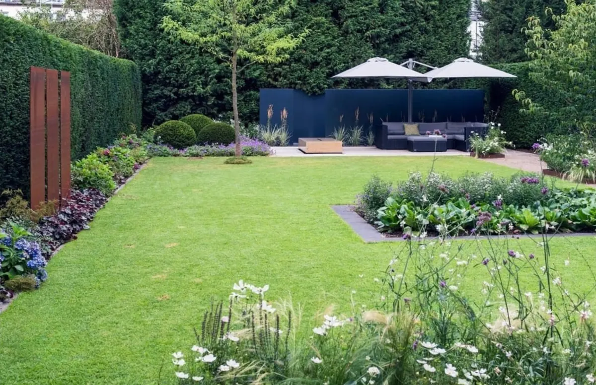 Gepflegter Garten mit Rasenfläche, Beeten und Terrasse